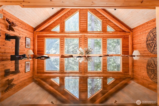 interior space featuring wooden ceiling, wood walls, wood finished floors, and beamed ceiling