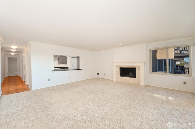 unfurnished living room with crown molding, a fireplace, and carpet floors