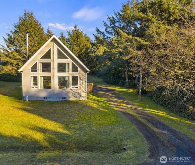 view of side of home featuring crawl space, a lawn, and driveway