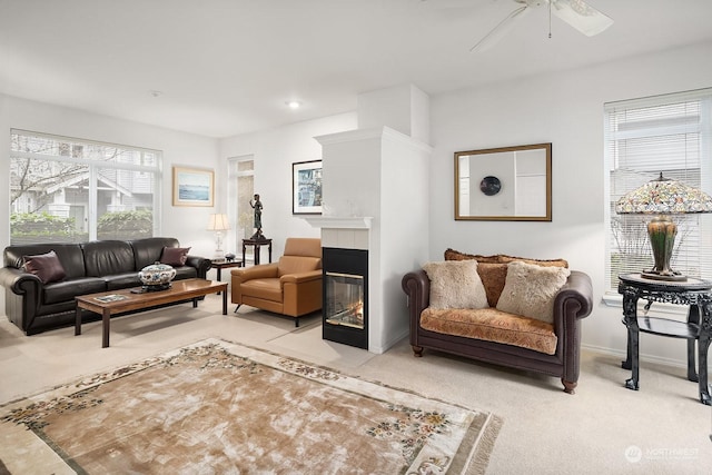 living room with ceiling fan, a healthy amount of sunlight, light carpet, and a fireplace