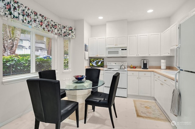 kitchen featuring white cabinets and white appliances