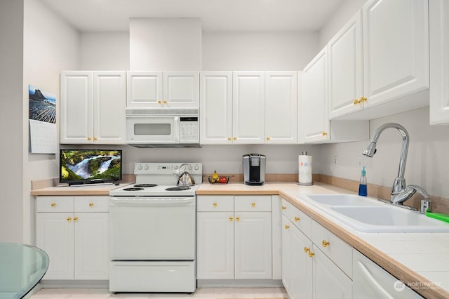 kitchen with white cabinetry, sink, and white appliances