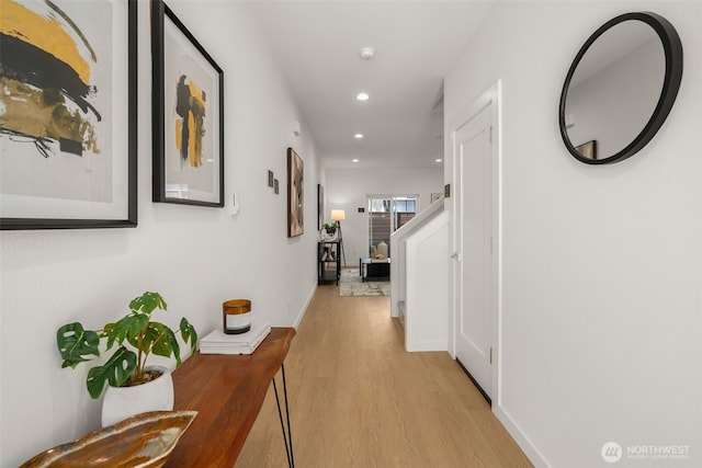 corridor with light wood-style flooring, baseboards, and recessed lighting