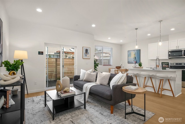 living room featuring light wood-style floors, baseboards, and recessed lighting