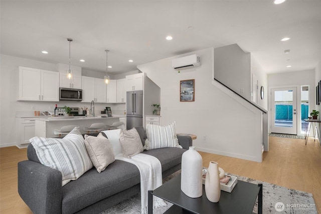 living area with light wood-type flooring, baseboards, and recessed lighting