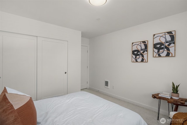 bedroom featuring a closet, visible vents, light carpet, and baseboards