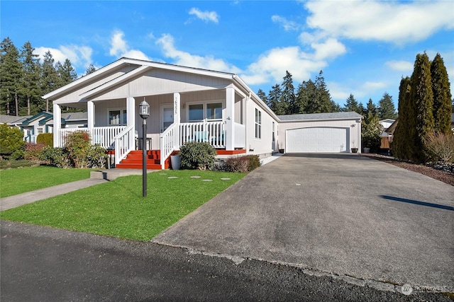 view of front of property featuring a garage, a front yard, and covered porch