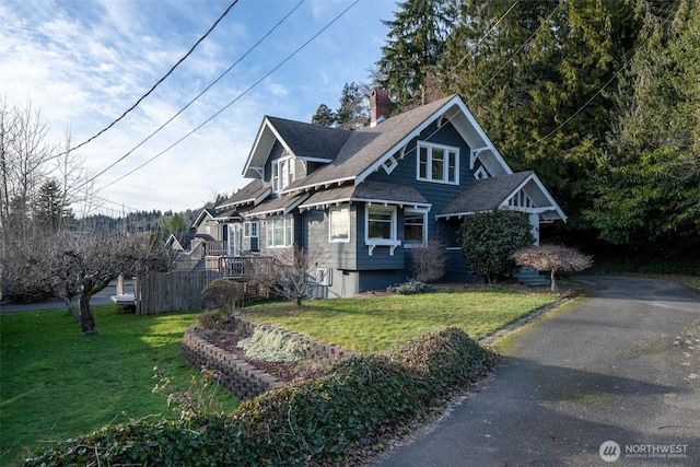 view of front of house featuring fence, a chimney, and a front lawn