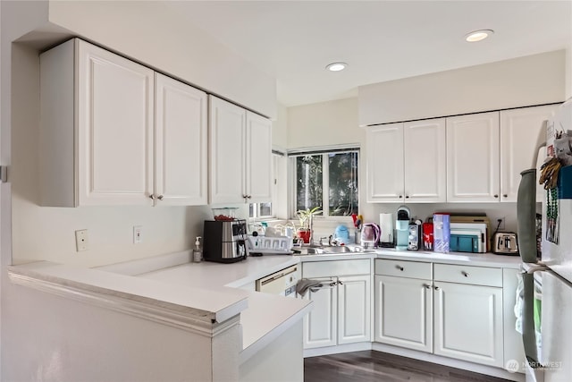 kitchen featuring white cabinetry, dark wood-type flooring, fridge, and kitchen peninsula