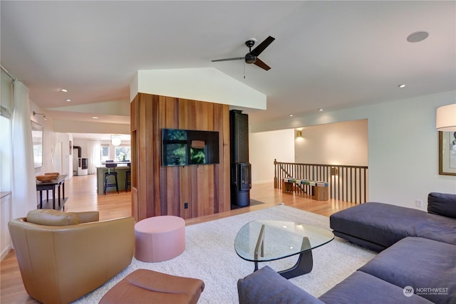 living room featuring vaulted ceiling, ceiling fan, and light wood-type flooring