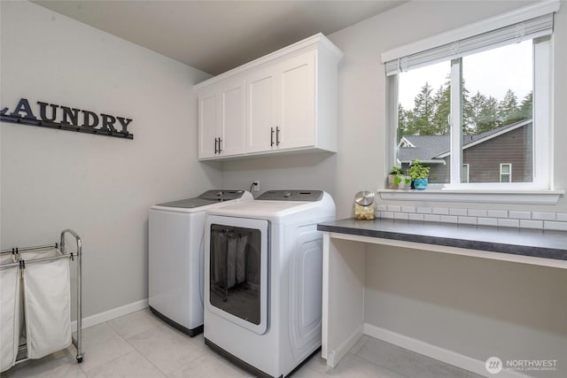 laundry area featuring independent washer and dryer, light tile patterned floors, and cabinets