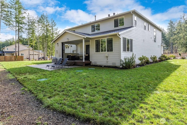 back of property with a yard and a patio area