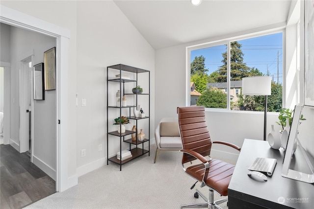 carpeted office space with vaulted ceiling