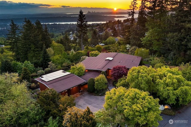 aerial view at dusk featuring a water view