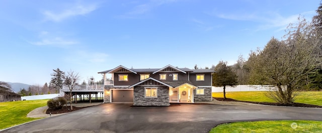 craftsman-style house with a garage, a front lawn, and a carport