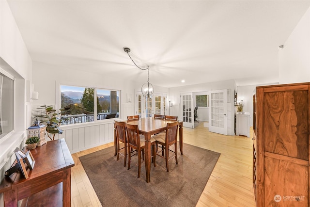 dining room with hardwood / wood-style flooring, a notable chandelier, and french doors