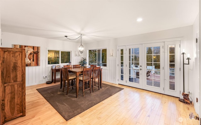 dining room with french doors, a chandelier, and light wood-type flooring