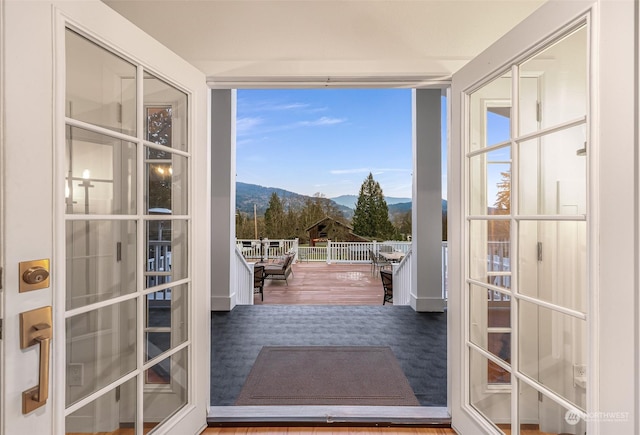 doorway to outside featuring french doors, expansive windows, a mountain view, and hardwood / wood-style floors