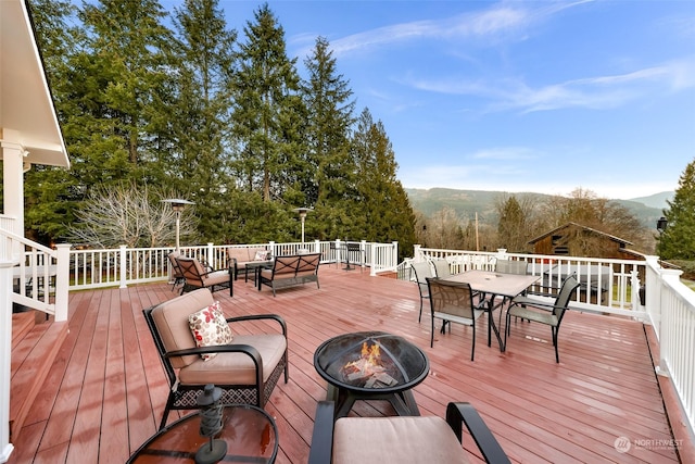 wooden terrace with a mountain view and an outdoor living space with a fire pit