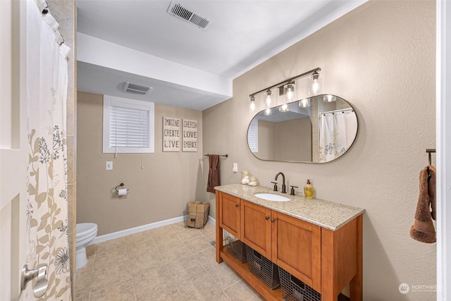 bathroom with tile patterned flooring, vanity, and toilet