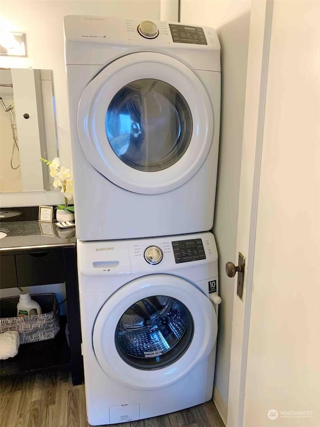 washroom with stacked washer and dryer and dark wood-type flooring