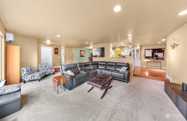 carpeted living room with rail lighting and an AC wall unit