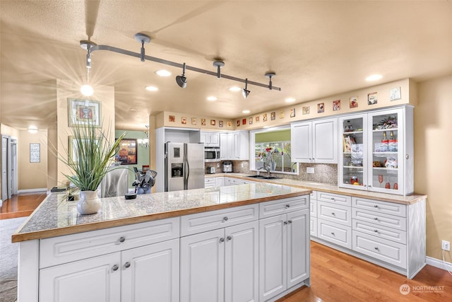 kitchen with pendant lighting, sink, stainless steel appliances, and white cabinets