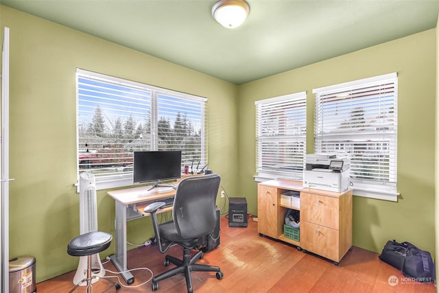 home office with light hardwood / wood-style flooring and plenty of natural light