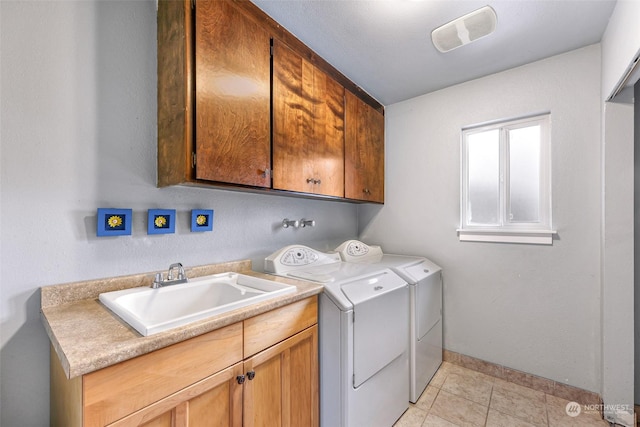 laundry room featuring cabinets, washer and clothes dryer, sink, and light tile patterned floors