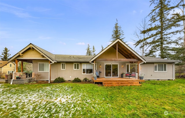 rear view of house featuring a lawn and a deck