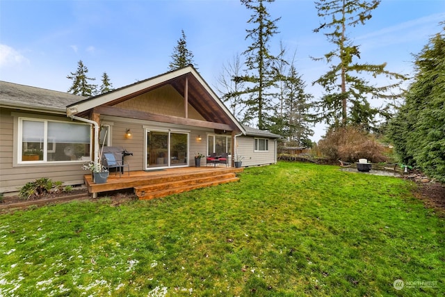 rear view of property with a yard and a deck