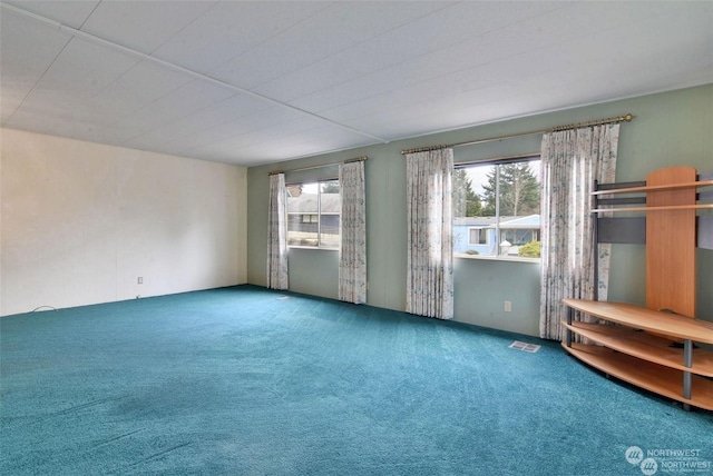 carpeted empty room with plenty of natural light