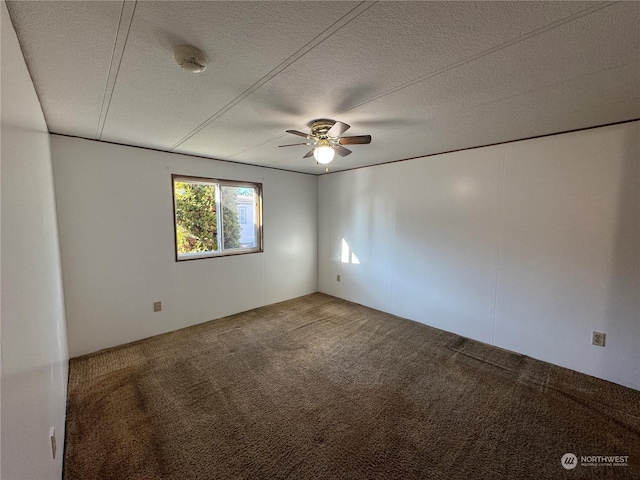 carpeted spare room featuring ceiling fan and a textured ceiling