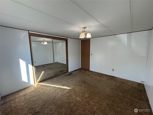 unfurnished bedroom with carpet floors, a textured ceiling, and a closet