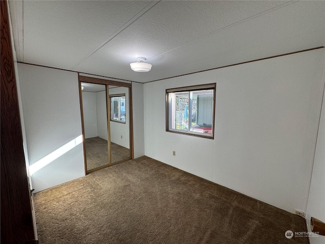 unfurnished bedroom with a closet, a textured ceiling, and carpet flooring