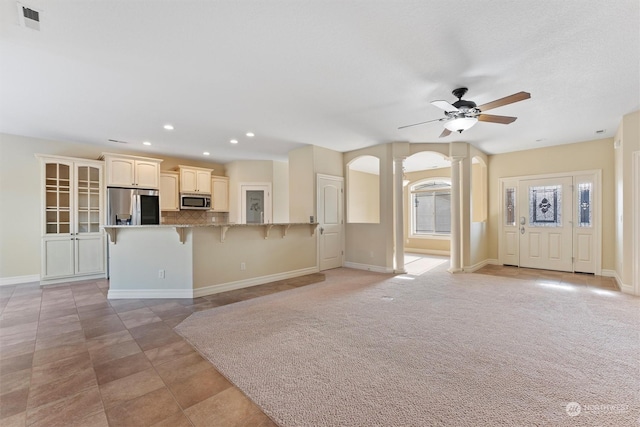 unfurnished living room featuring light carpet and ceiling fan