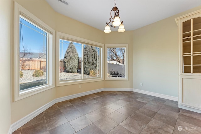 unfurnished dining area featuring a notable chandelier and tile patterned floors