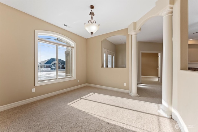 carpeted spare room with ornate columns