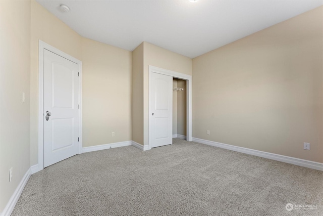 unfurnished bedroom featuring light carpet and a closet