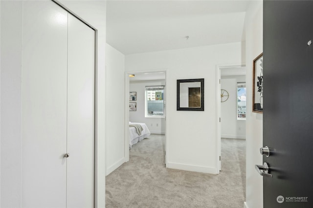 hallway featuring light colored carpet