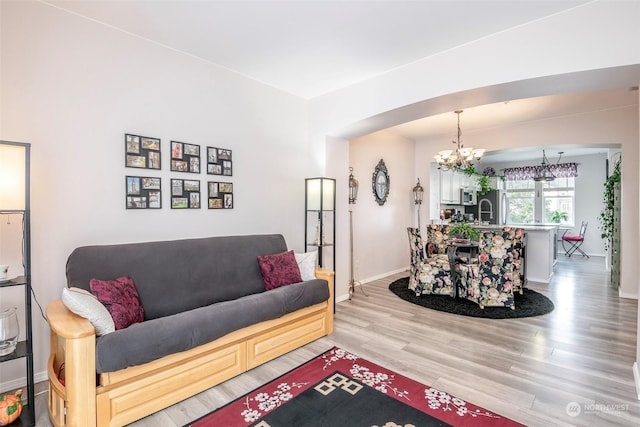 living room featuring hardwood / wood-style flooring, sink, and a notable chandelier