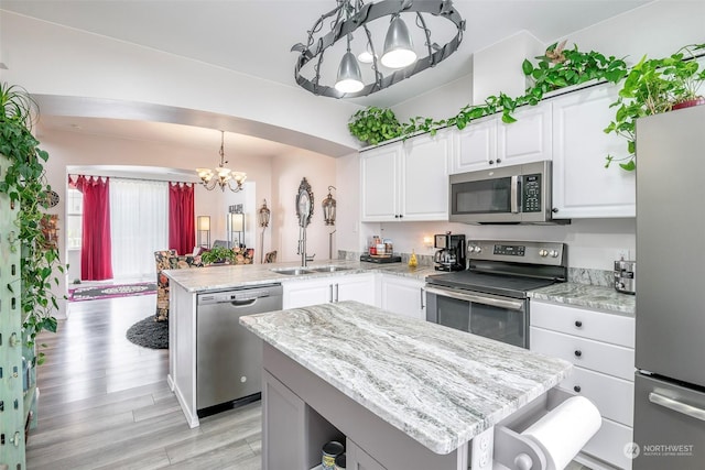 kitchen with a kitchen island, pendant lighting, white cabinets, kitchen peninsula, and stainless steel appliances