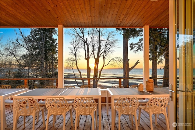 exterior space featuring a water view, outdoor dining area, and a view of the beach