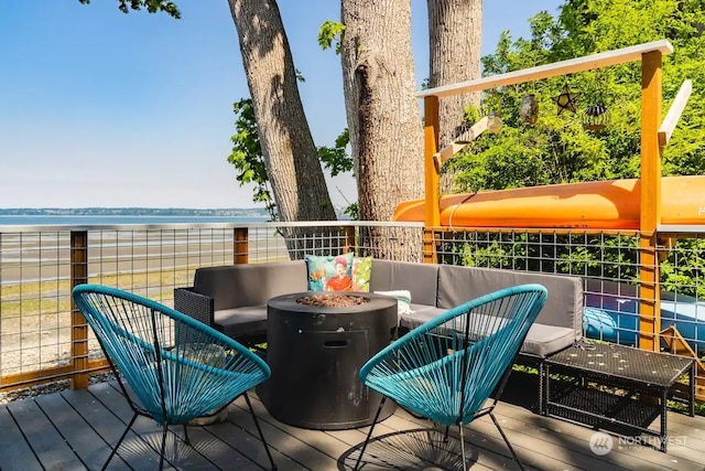 balcony with a water view and an outdoor living space with a fire pit