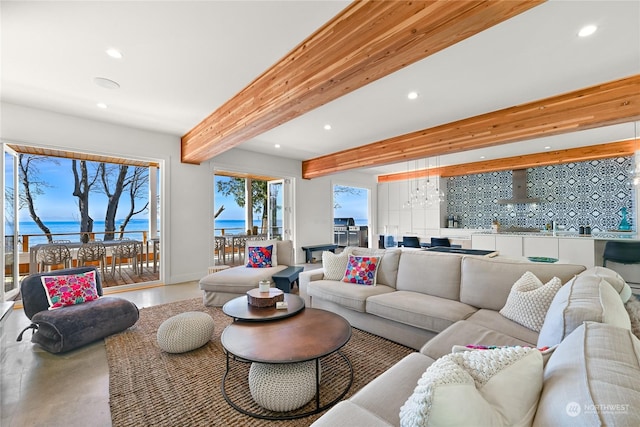 living area with beamed ceiling, a water view, and recessed lighting