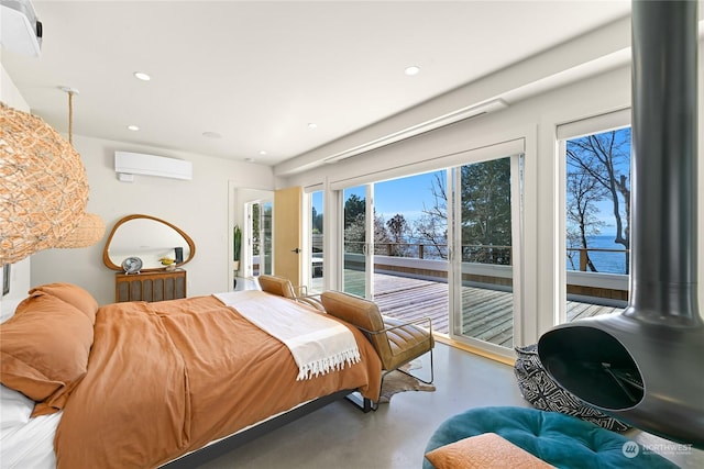 bedroom with a wall unit AC, recessed lighting, concrete floors, a water view, and access to exterior