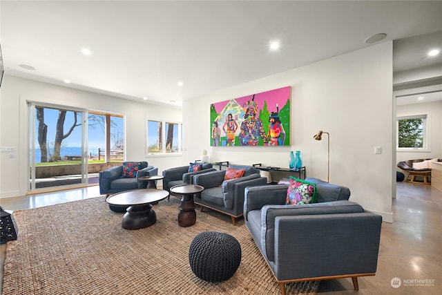 living area featuring a healthy amount of sunlight, concrete flooring, and recessed lighting