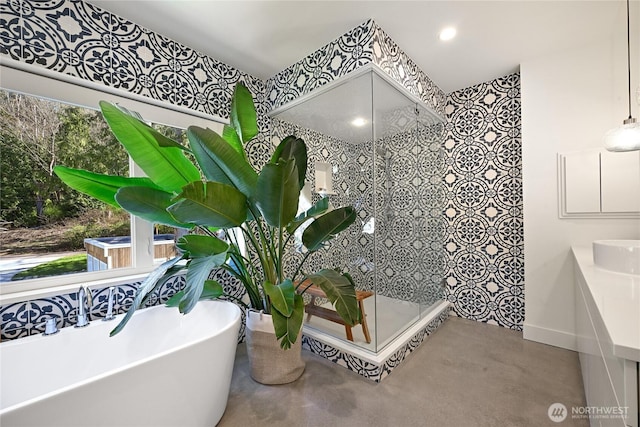 bathroom with baseboards, a walk in shower, a freestanding tub, and finished concrete floors