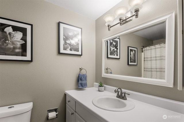 bathroom featuring vanity, a chandelier, and toilet