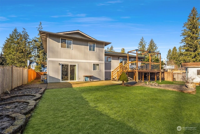 rear view of property with a wooden deck and a lawn